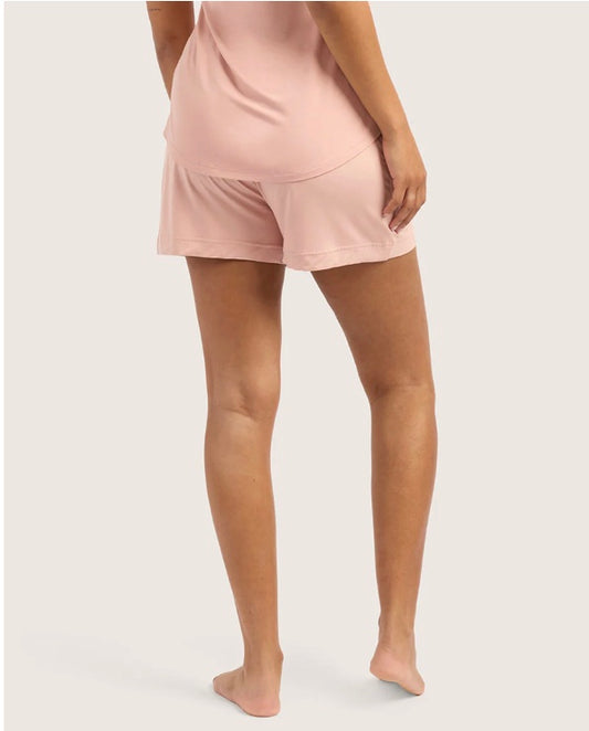 Person wearing pink shorts with a white background