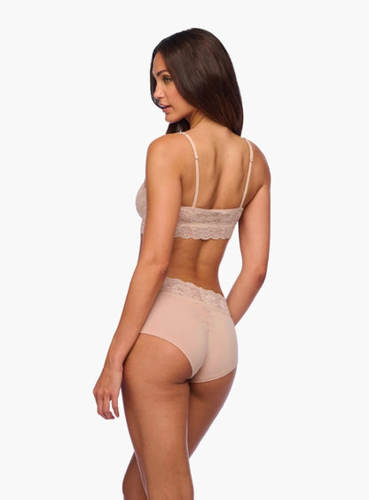 Woman wearing a beige lace lingerie set on a white background
