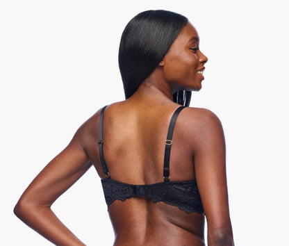 Woman wearing a black bralette on a white background