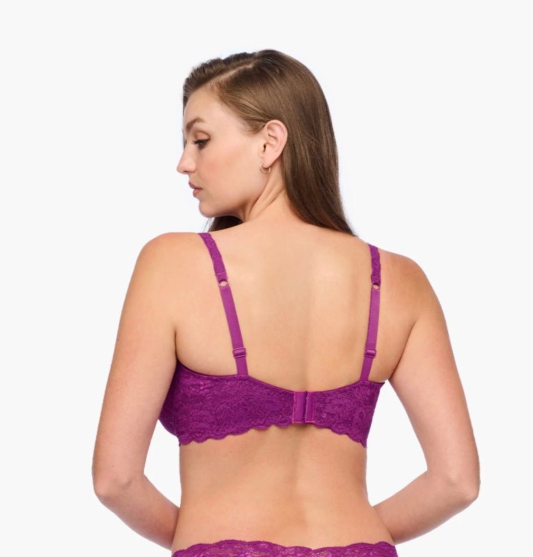 Woman wearing a purple bra and underwear set on a white background