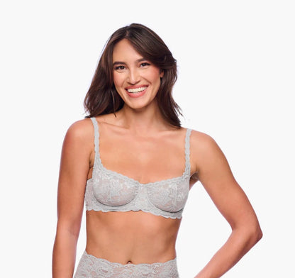Woman wearing a gray lace bra and panties set on a white background