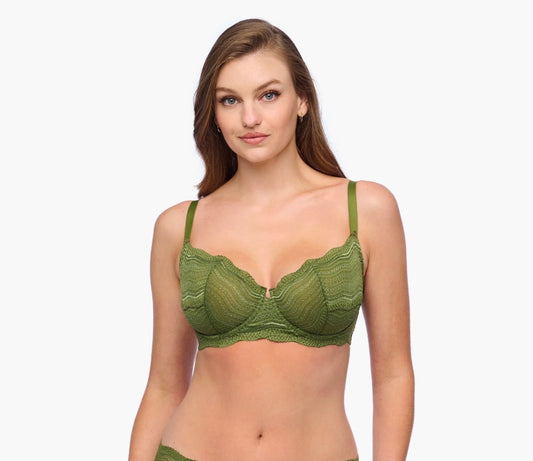 Woman wearing a green bralette against a white background