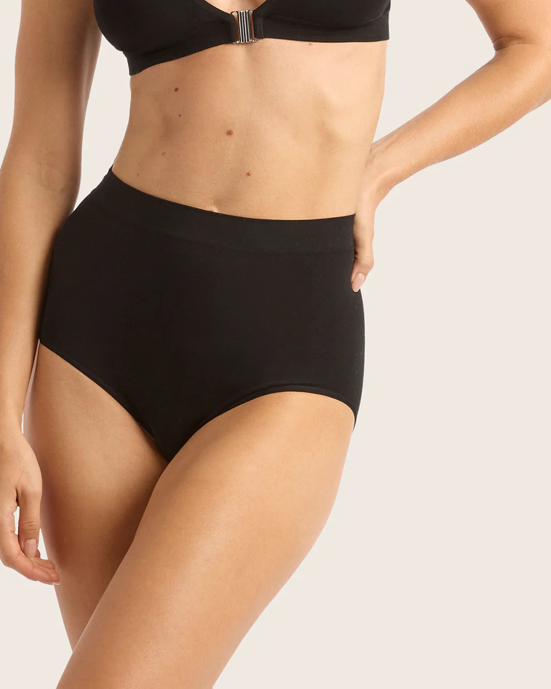 Person wearing a black bikini set on a plain background