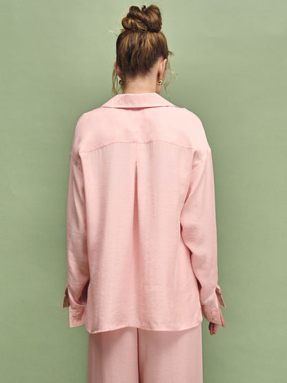 Person wearing a pink outfit against a green background