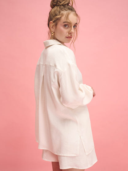 Woman wearing a light pink coat against a pink background