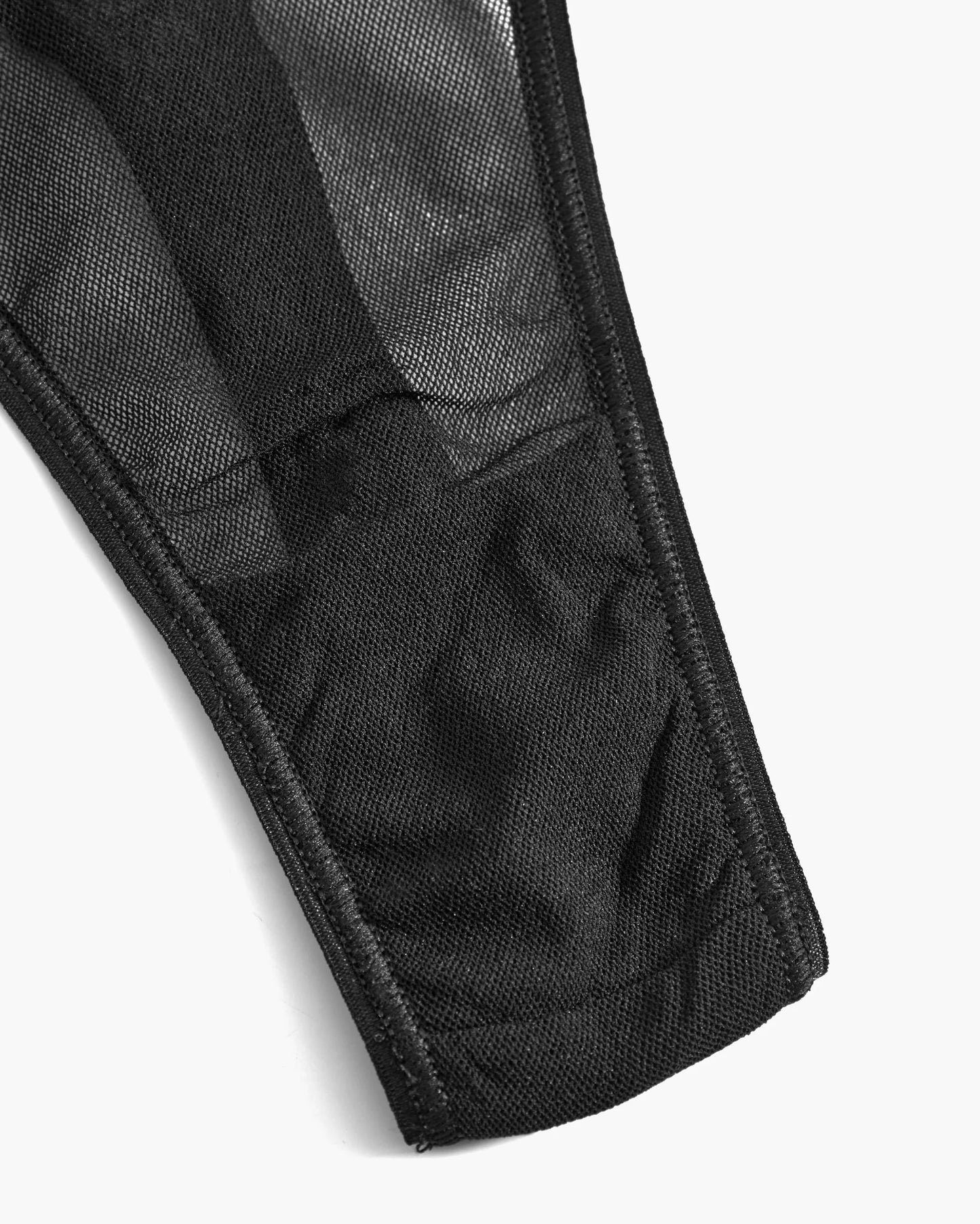 Close-up of a black fabric with visible stitching on a white background