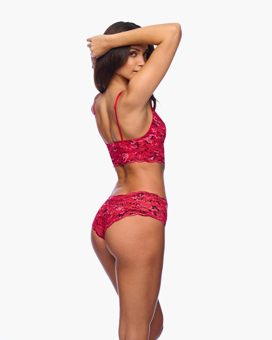 Woman wearing a red lace lingerie set on a white background