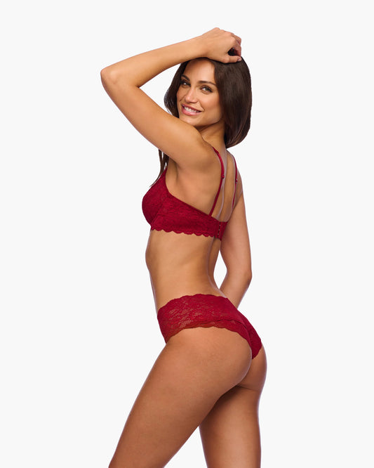 Woman wearing a red lace lingerie set on a white background