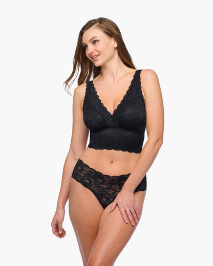 Woman wearing a black lace lingerie set on a white background