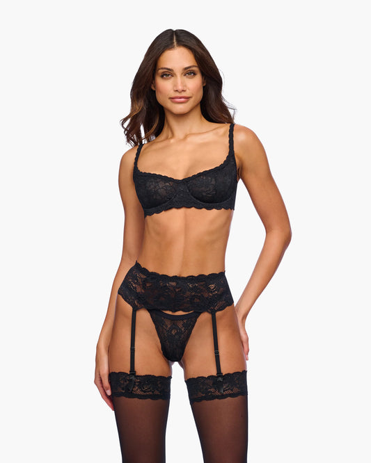 Woman wearing a black lace lingerie set on a white background