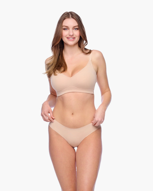 Woman wearing a beige bikini set on a white background