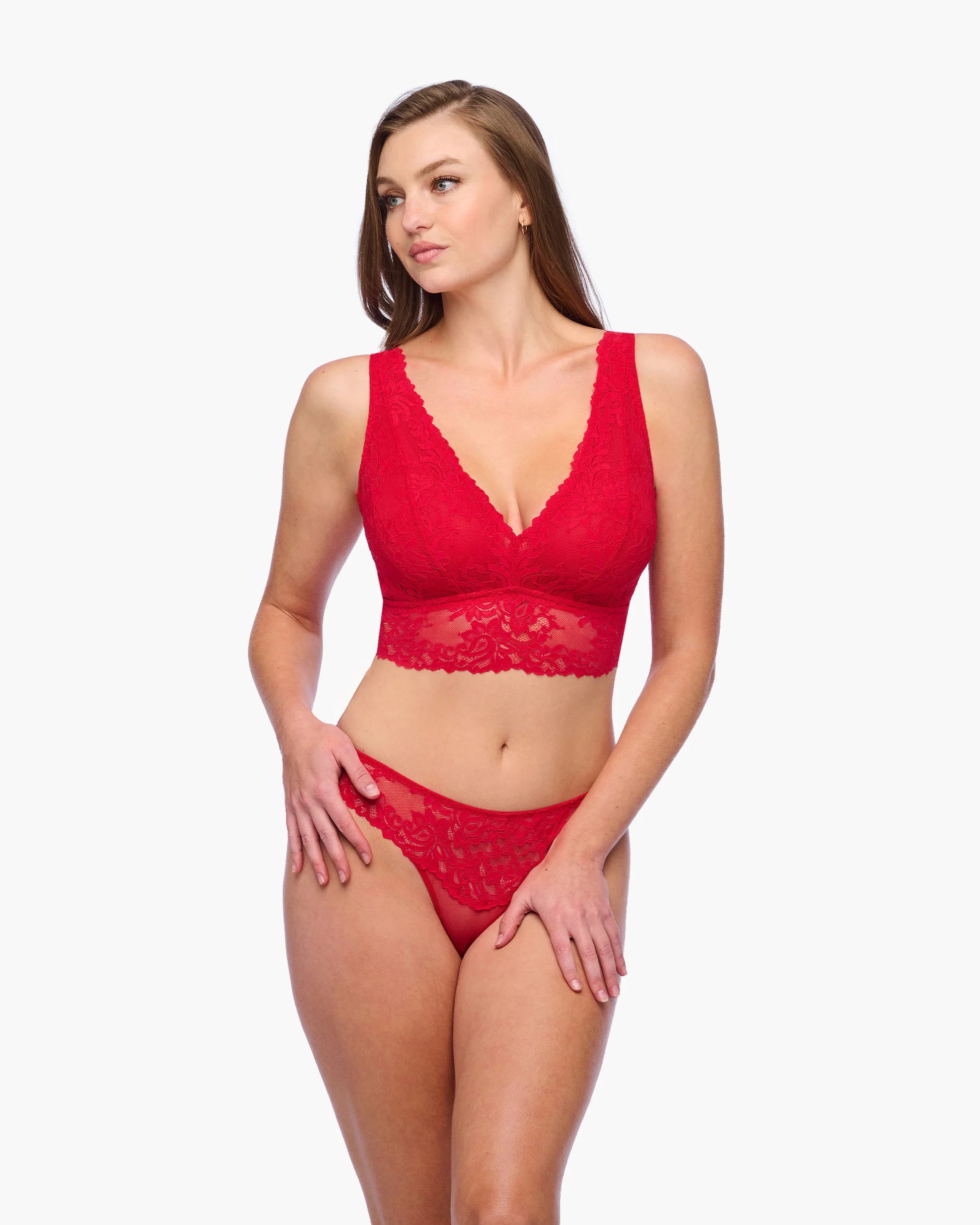Woman wearing a red lace lingerie set on a white background