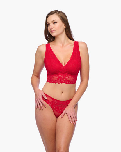 Woman wearing a red lace lingerie set on a white background
