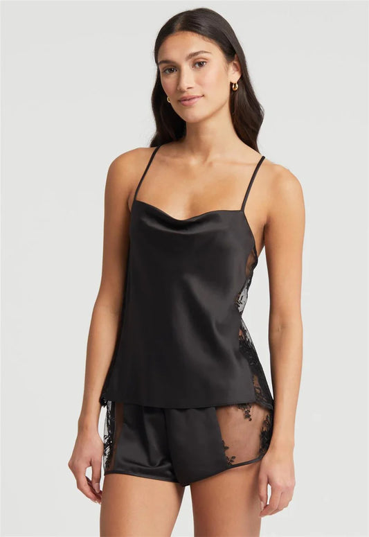 Woman wearing a black satin nightgown with lace details on a white background
