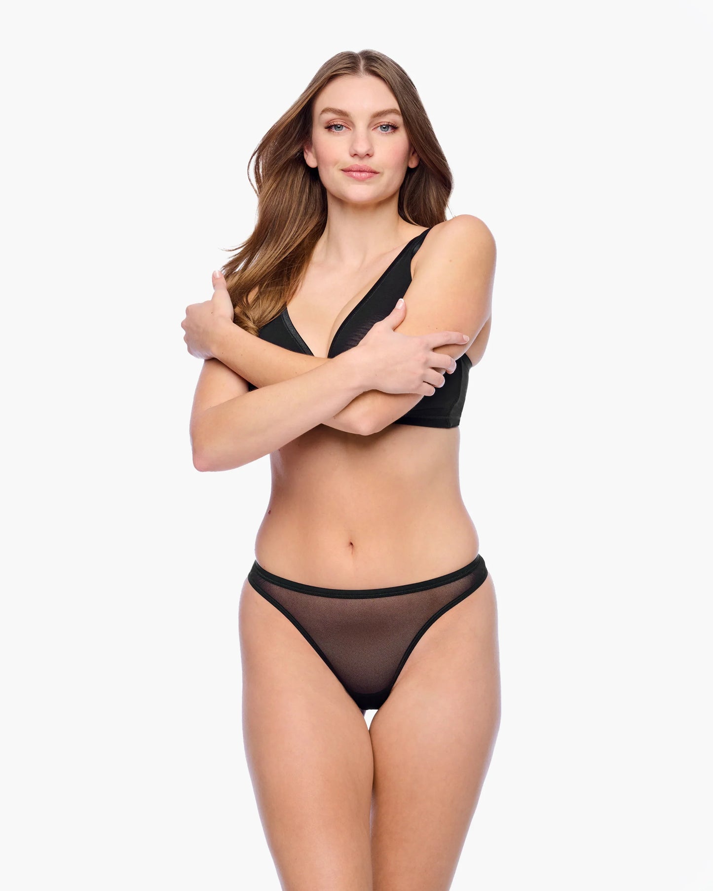 Woman wearing a black lingerie set on a white background