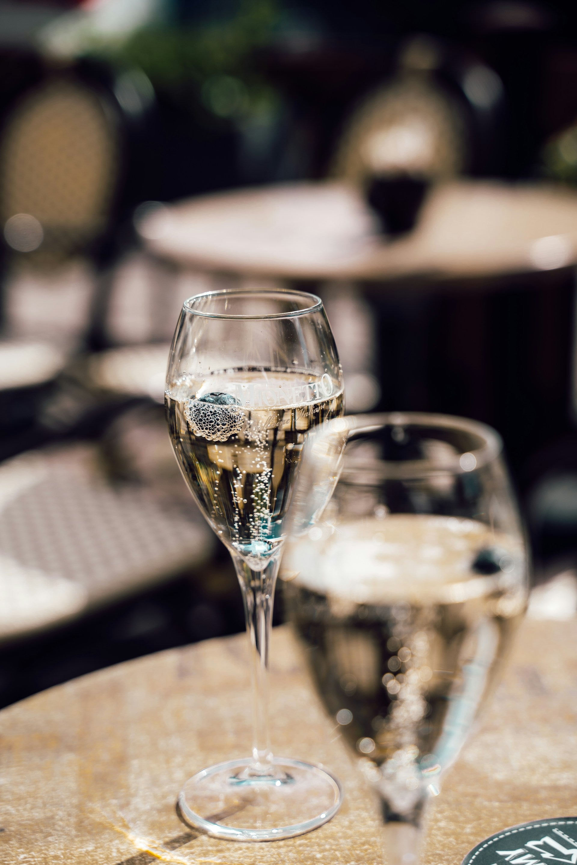 Two wine glasses on a table with a blurred background