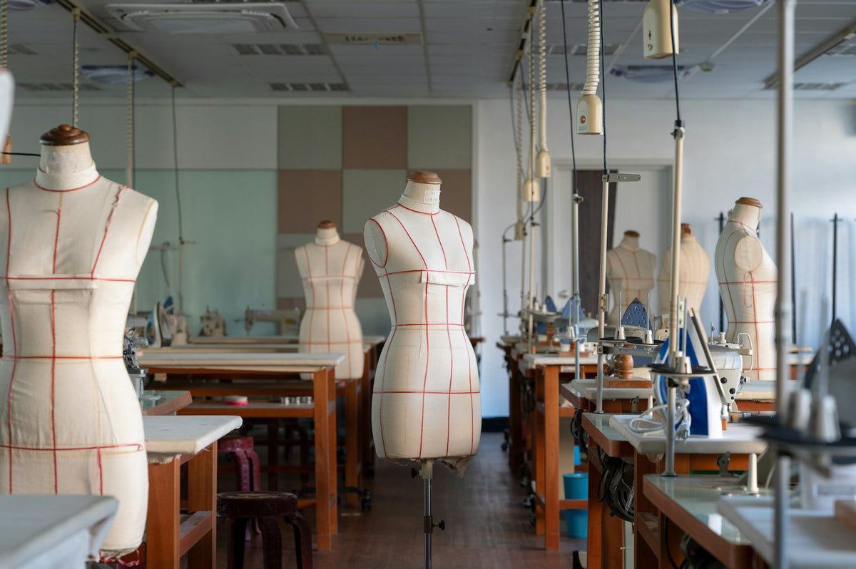 Interior of a fashion design studio with mannequins and workstations.