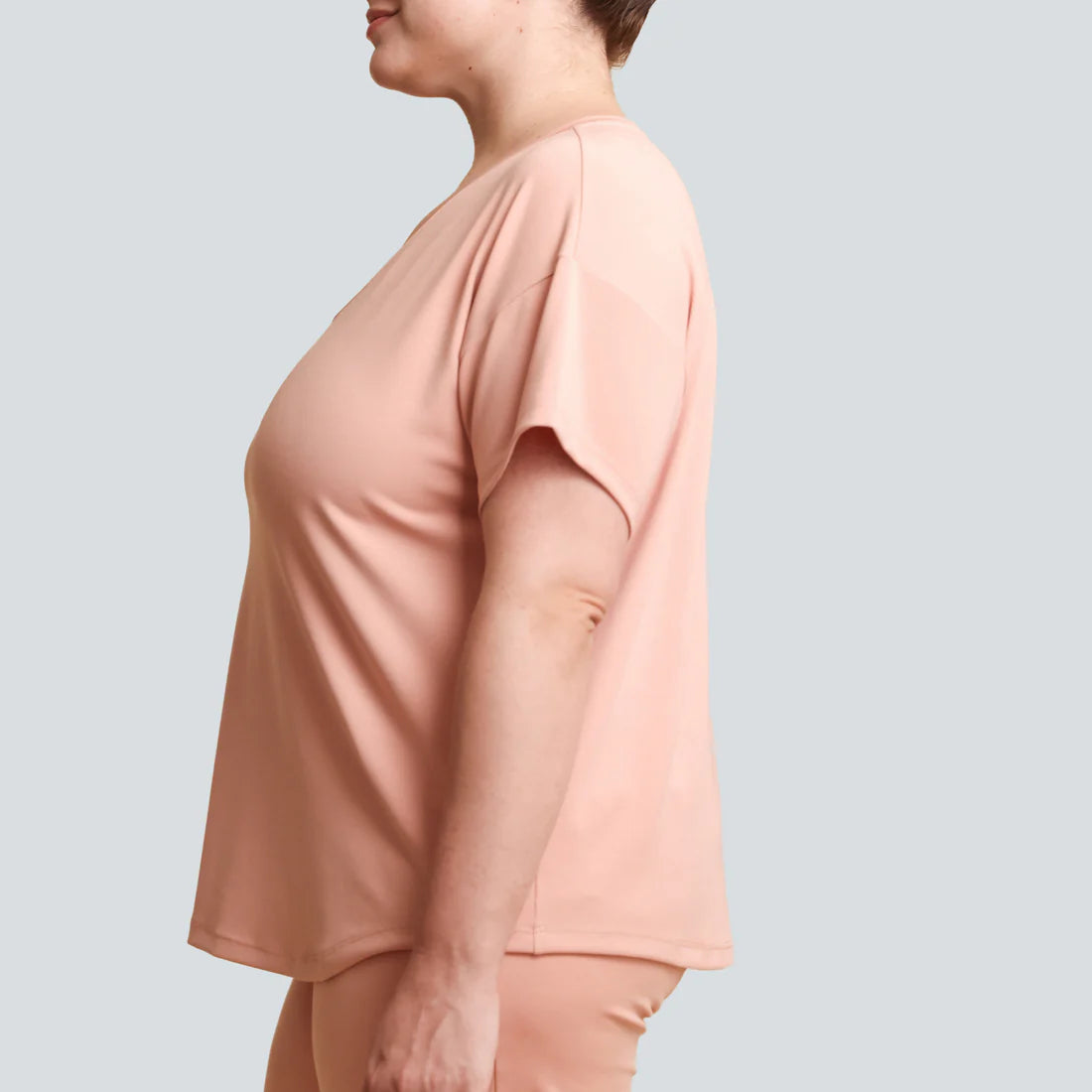 Person wearing a light pink outfit on a plain background