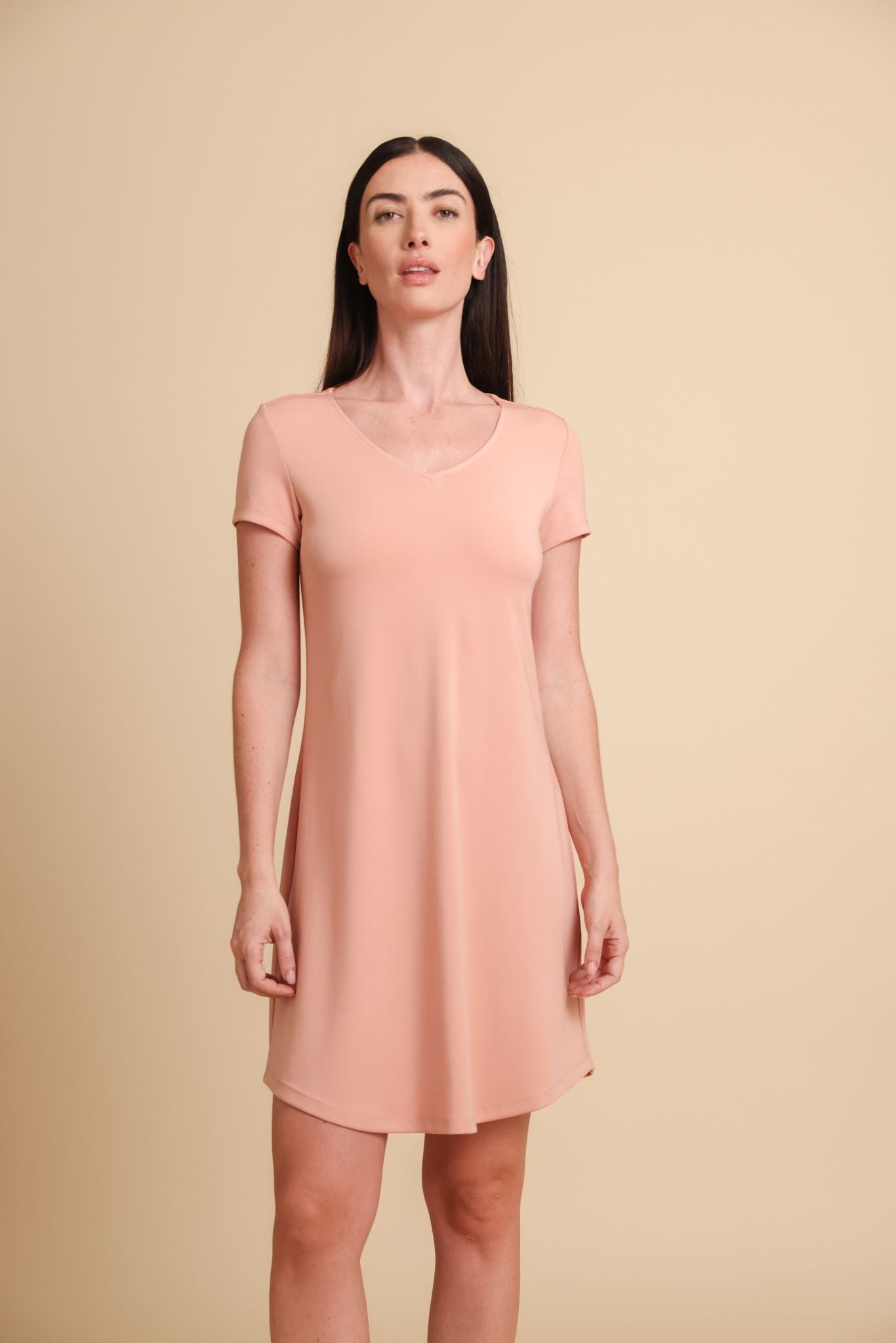 Woman wearing a pink dress against a beige background
