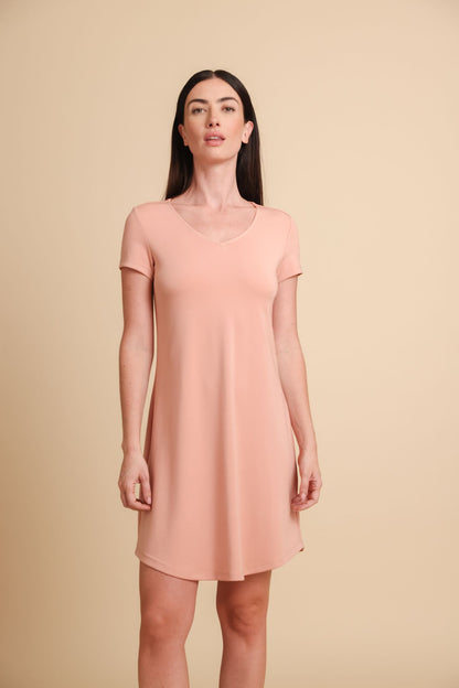 Woman wearing a pink dress against a beige background