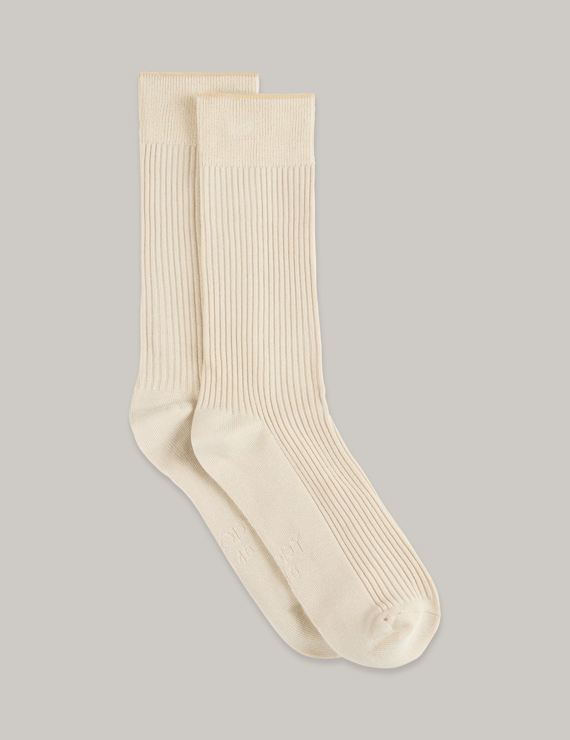 Pair of beige socks on a light gray background