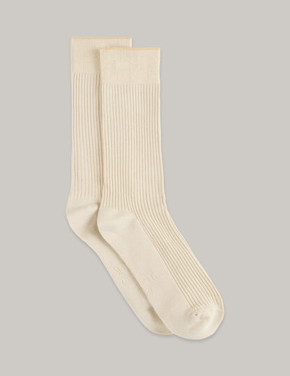 Pair of beige socks on a light gray background