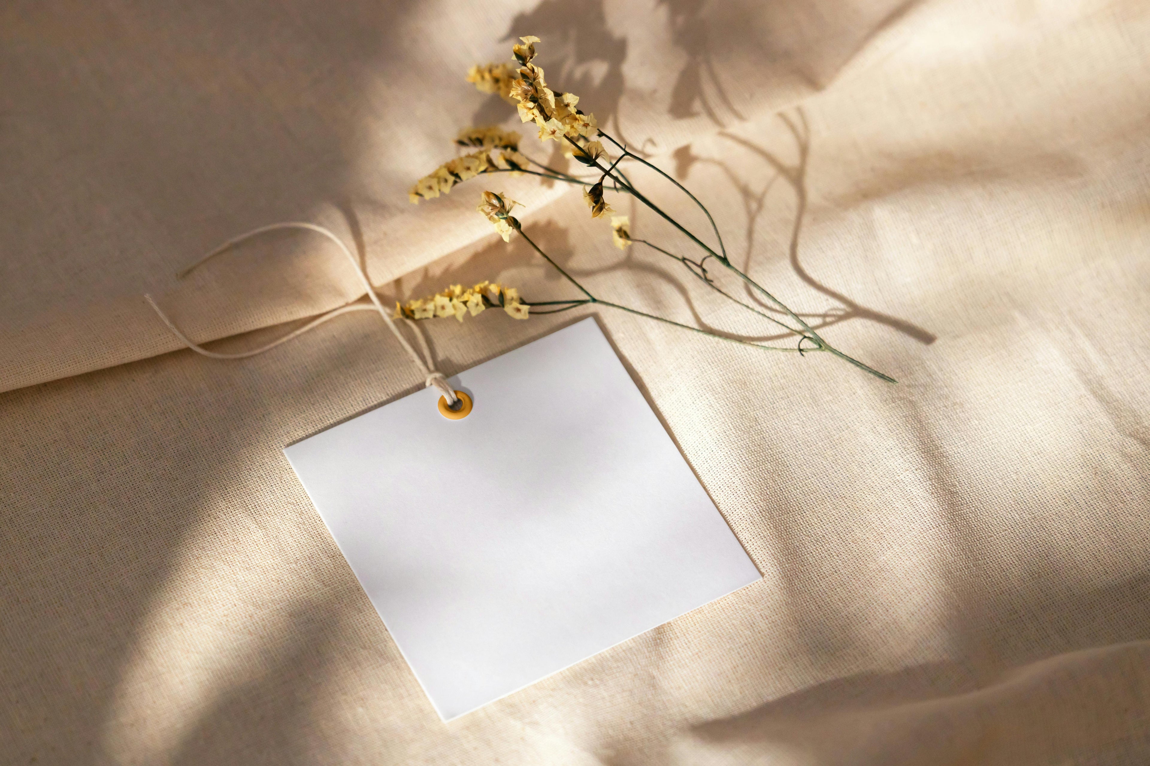 White card with yellow flowers on a beige fabric background
