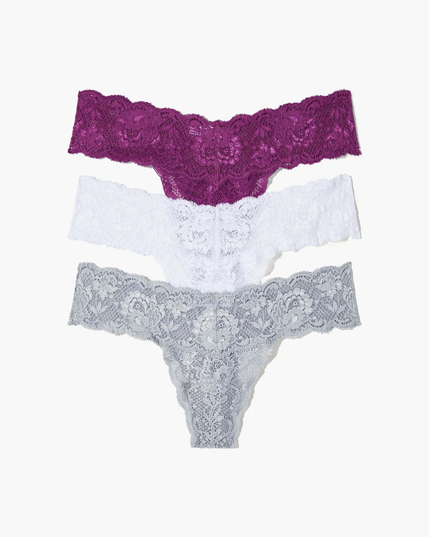 Set of three lace underwear pieces in purple, white, and gray on a white background