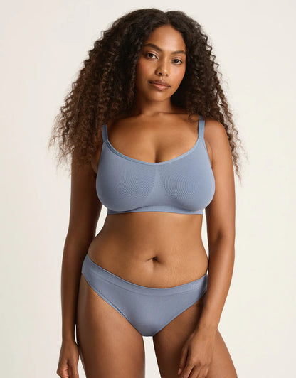 Woman wearing a light blue bikini set against a plain background