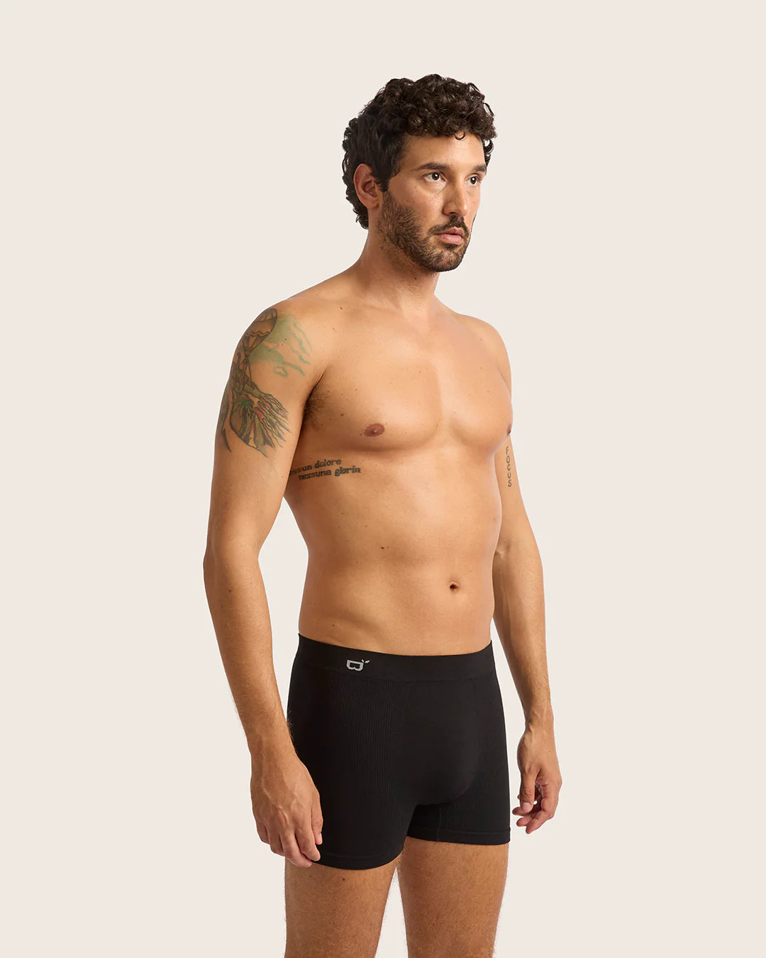 Man wearing black boxer briefs against a plain background