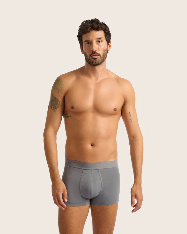 Man wearing gray underwear against a plain background