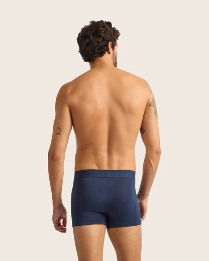 Man wearing navy blue underwear on a plain background