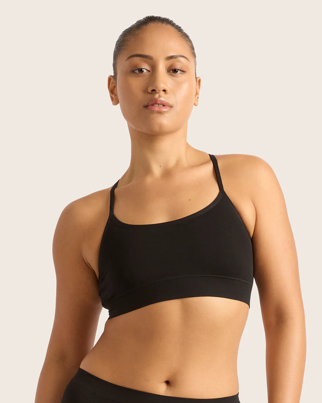 Woman wearing a black sports bra against a plain background