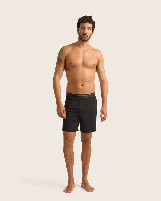 Man wearing black boxer briefs on a plain background