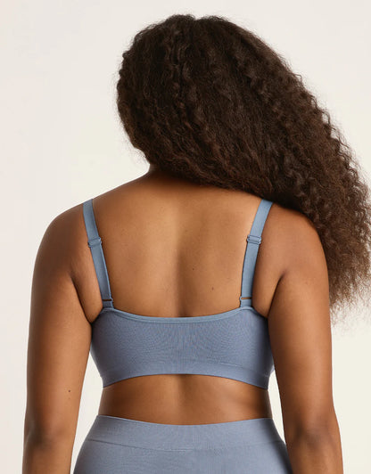 Person wearing a blue sports bra and leggings on a plain background