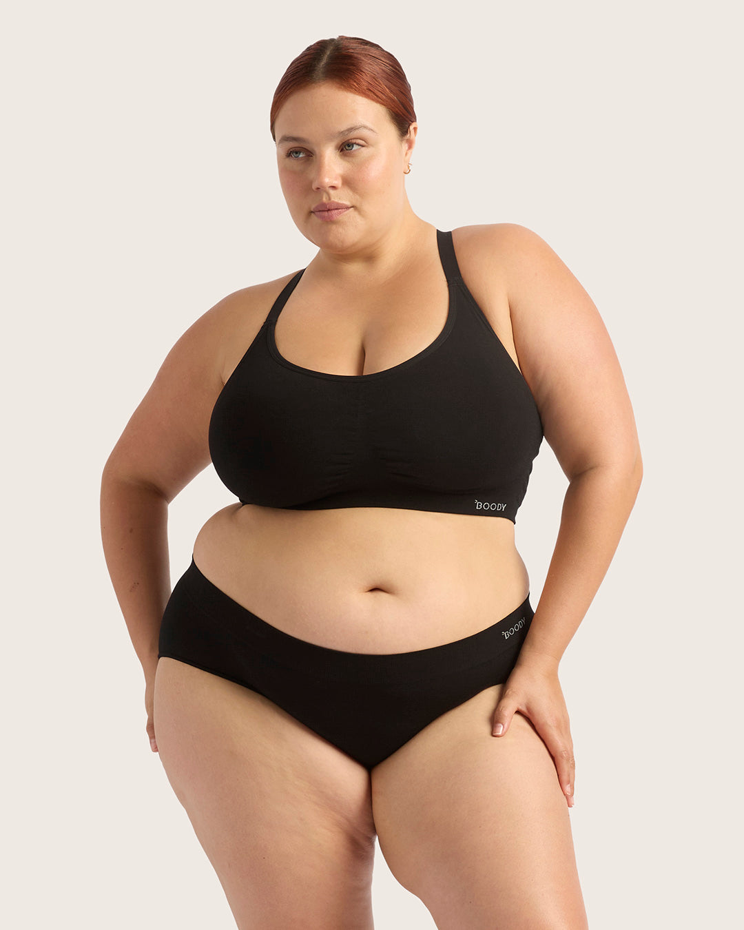 Person wearing a black bikini set on a plain background