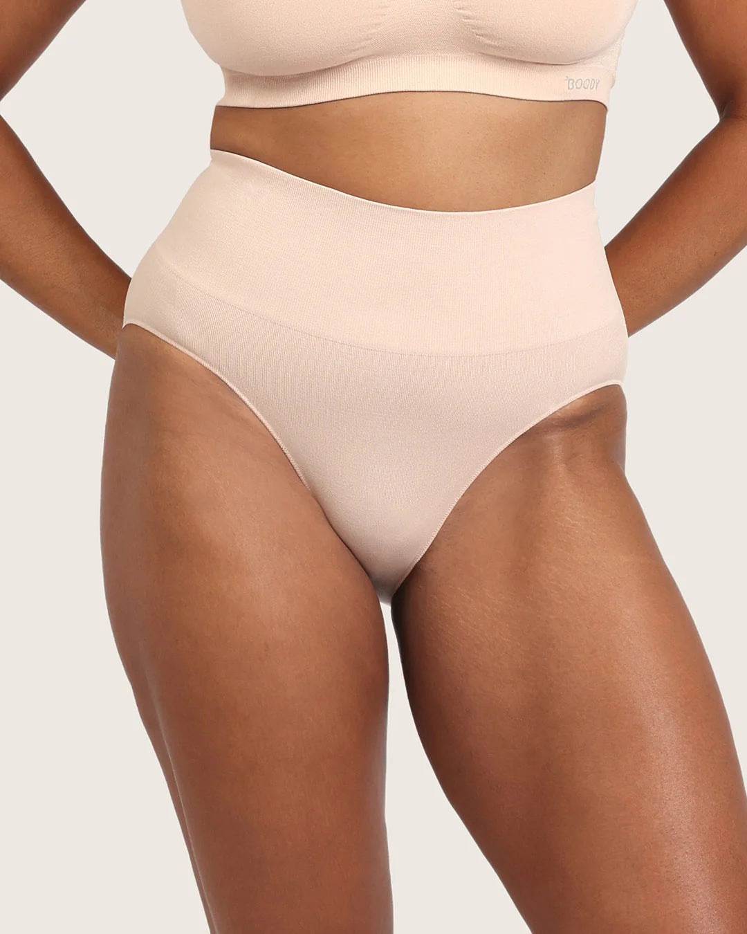 Beige high-waisted underwear worn by a model on a plain background