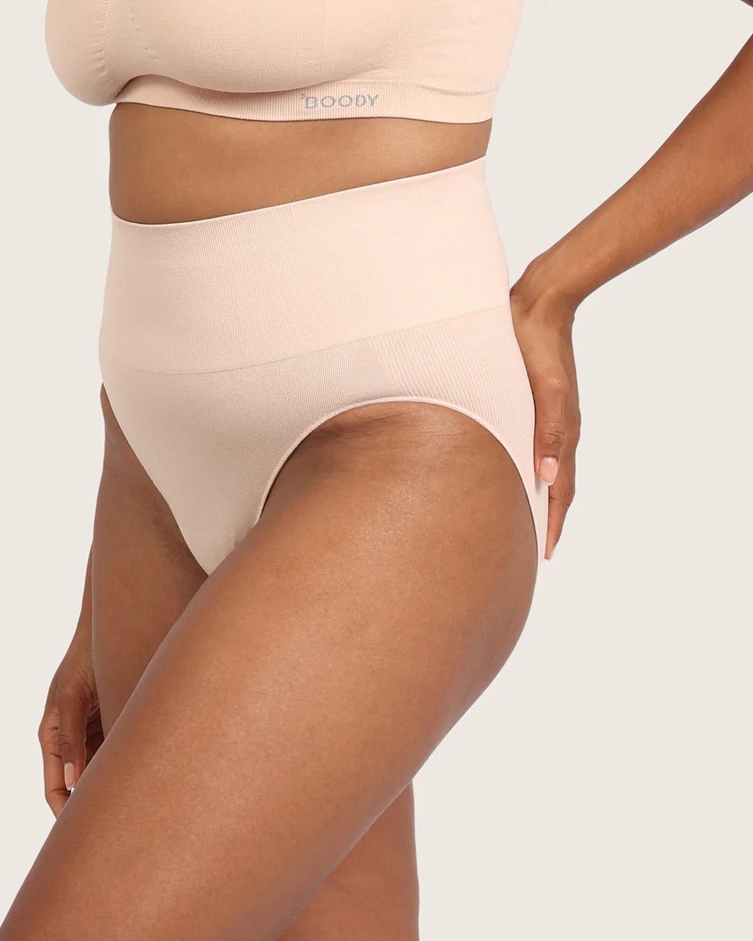 Beige shapewear being worn on a plain background