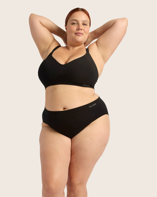 Woman wearing a black bikini set with a plain background