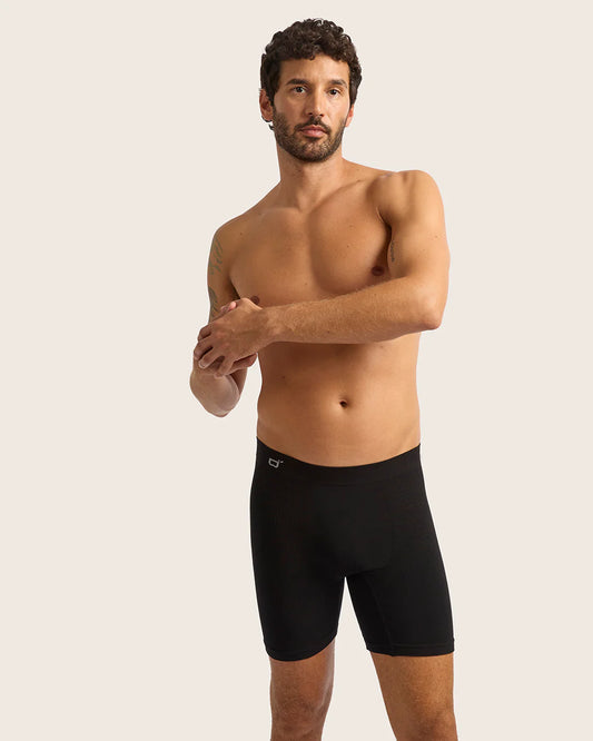 Man wearing black boxer briefs against a plain background
