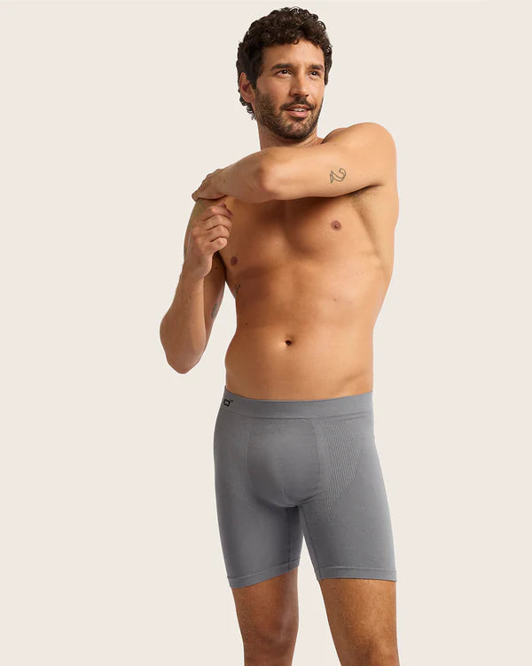 Man wearing gray boxer briefs against a plain background