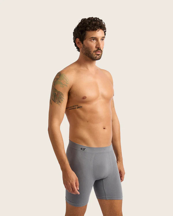 Man wearing gray boxer briefs against a plain background