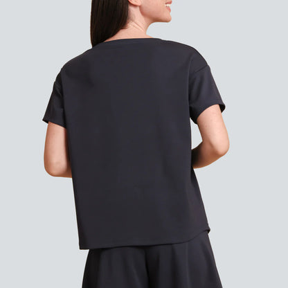 Person wearing a black outfit on a light gray background