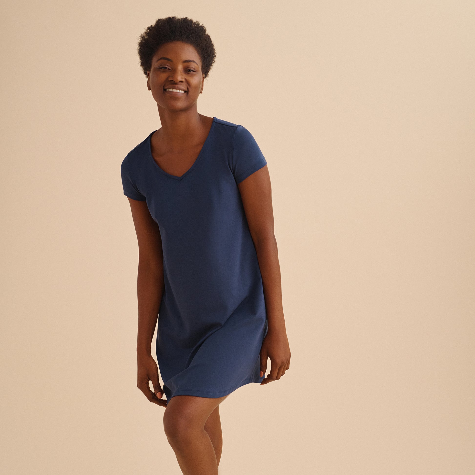 Woman wearing a blue dress against a beige background