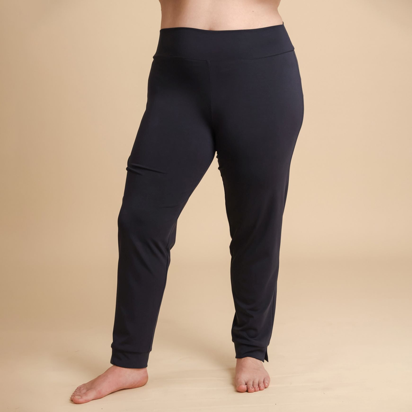 Black leggings worn by a person on a beige background