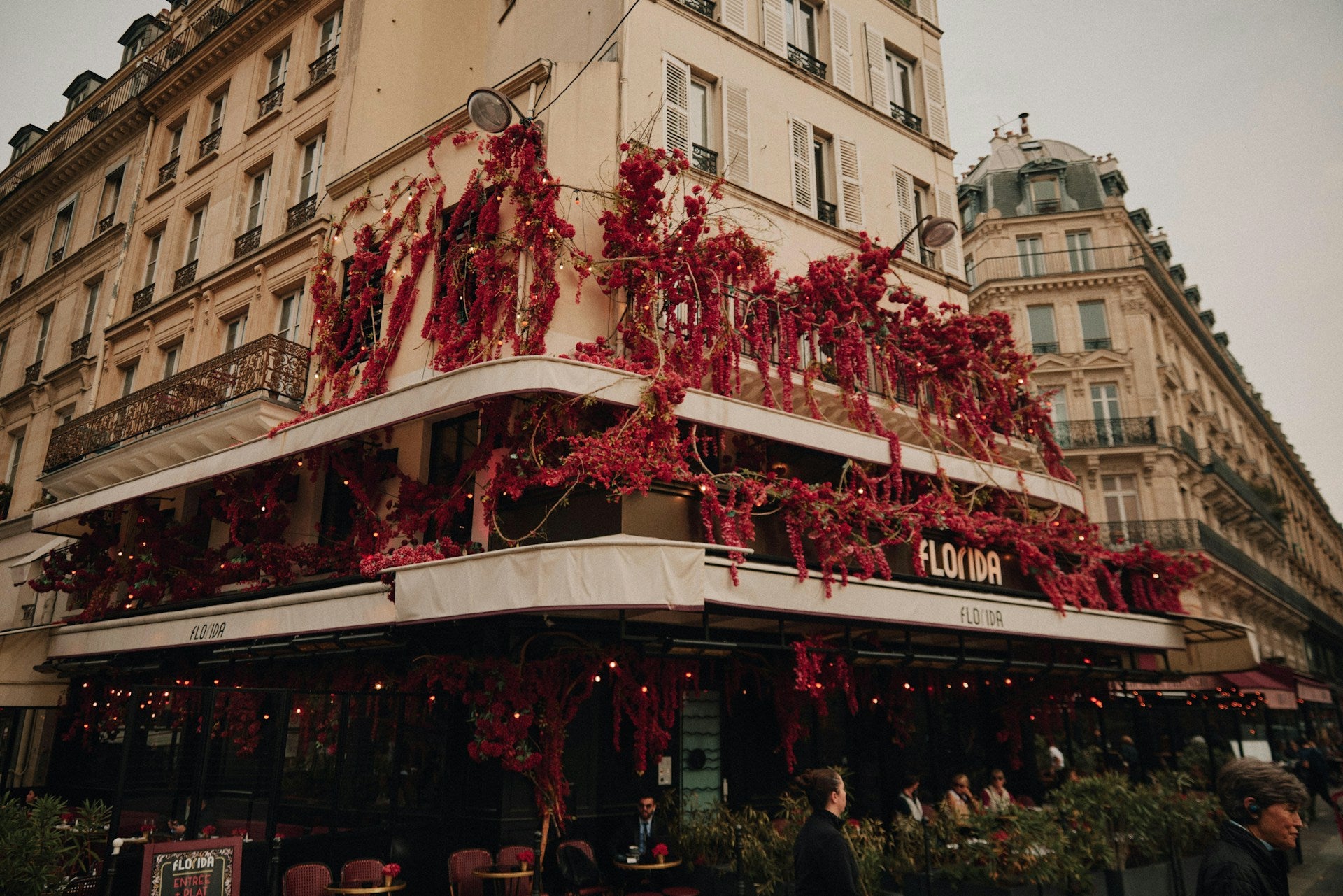 Parisian cafe with burgundy flowers.
