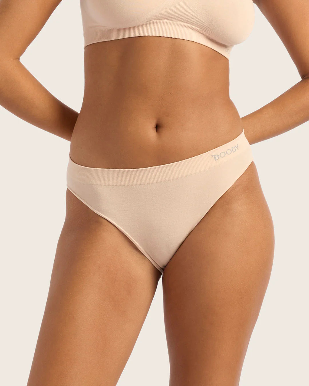 Beige underwear worn by a person on a plain background
