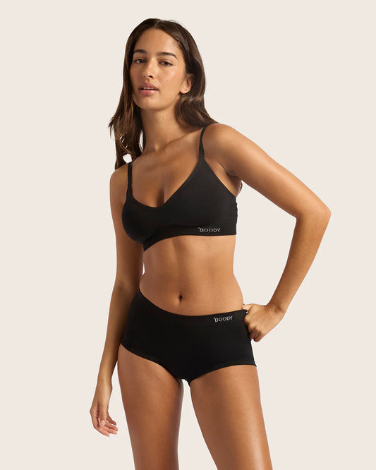 Woman wearing a black bikini set with a plain background