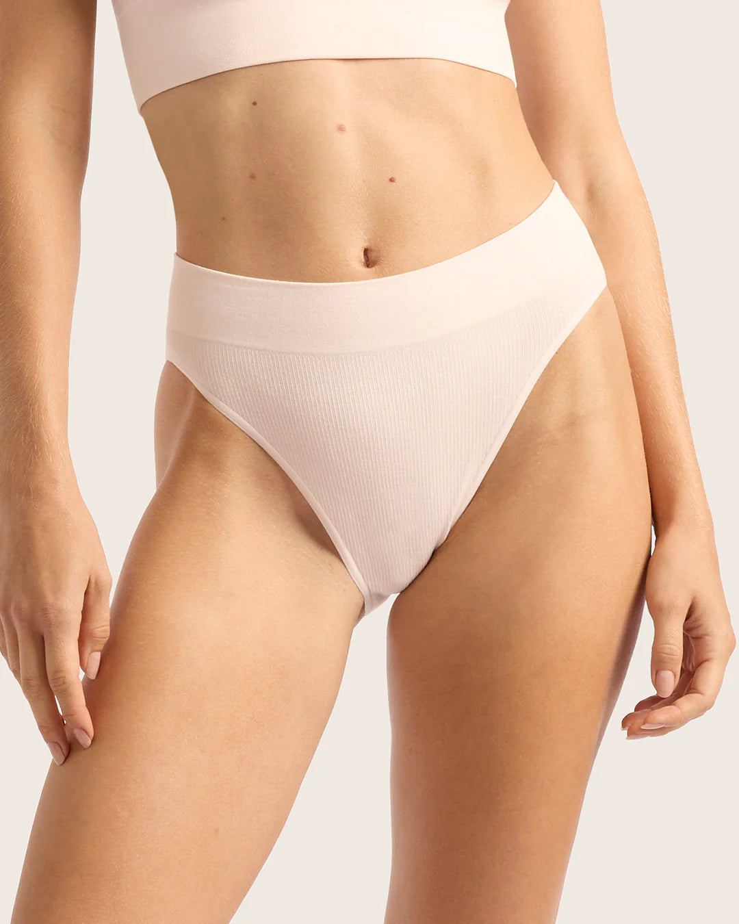 Beige high-waisted bikini bottom on a neutral background