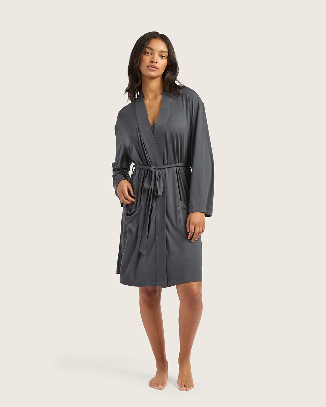 Woman wearing a gray robe on a plain background